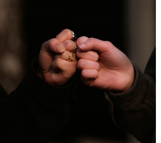 Image of 2 hands in fists touching. Photo by Taylor Smith on Unsplash
